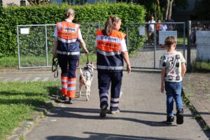 Rettungshund mit Besitzern gehen spazieren
